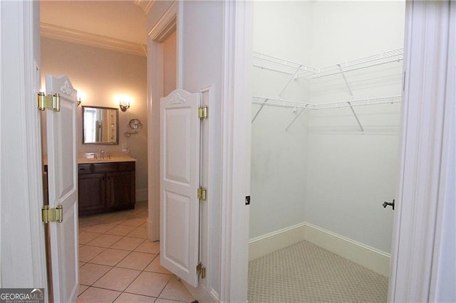walk in closet featuring a sink and light tile patterned floors
