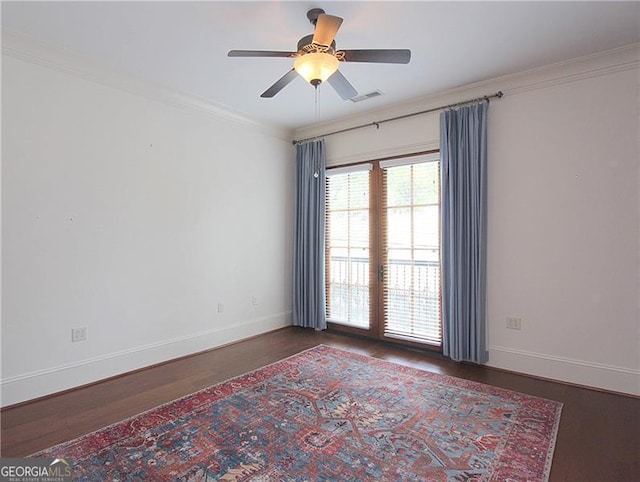 empty room with wood finished floors, ceiling fan, baseboards, and ornamental molding