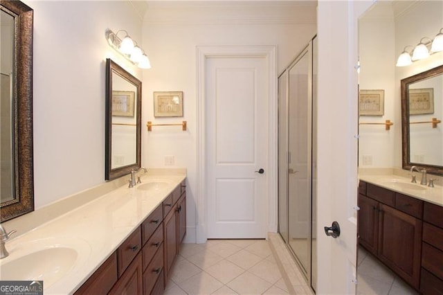 bathroom with tile patterned floors, crown molding, a stall shower, and double vanity
