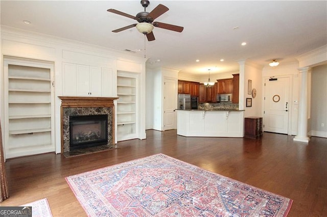 unfurnished living room featuring ceiling fan, crown molding, a premium fireplace, built in features, and baseboards