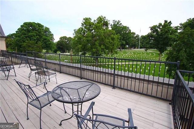 wooden terrace featuring view of wooded area