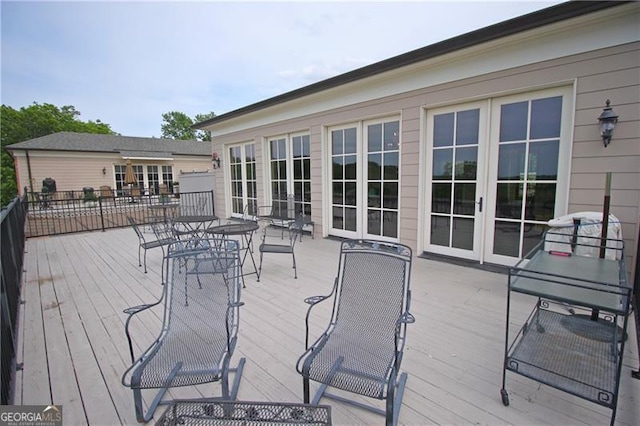 wooden terrace with french doors and outdoor dining space