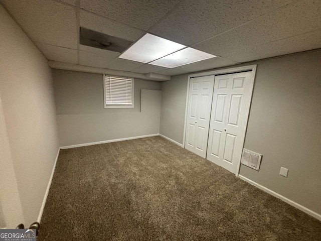 basement featuring carpet flooring and a paneled ceiling