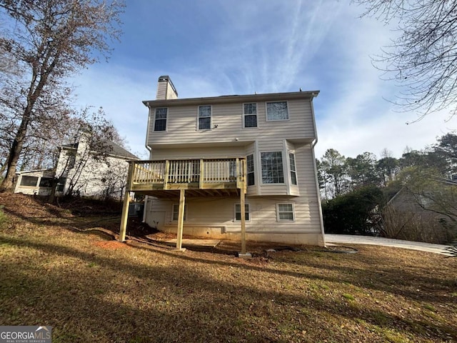 rear view of property with a lawn and a wooden deck