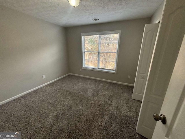 carpeted spare room featuring a textured ceiling