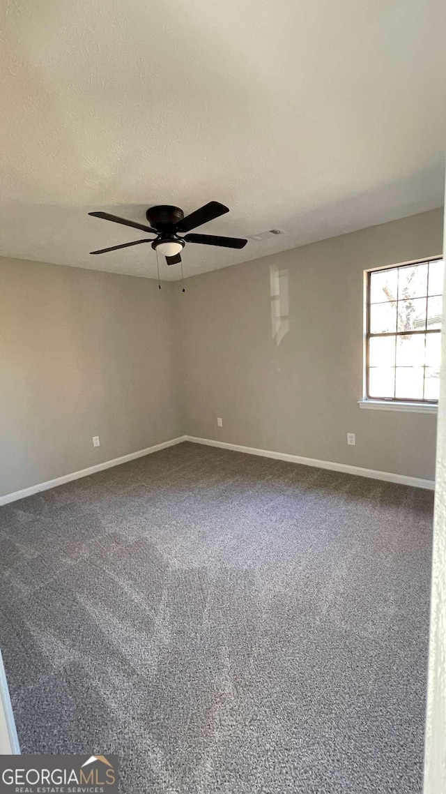 carpeted empty room with a textured ceiling and ceiling fan