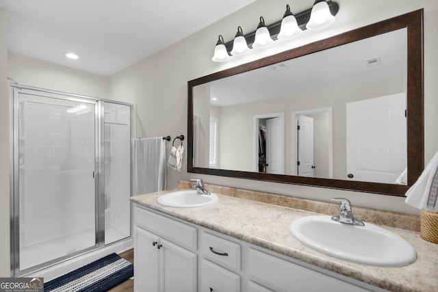 bathroom with a shower with door and vanity