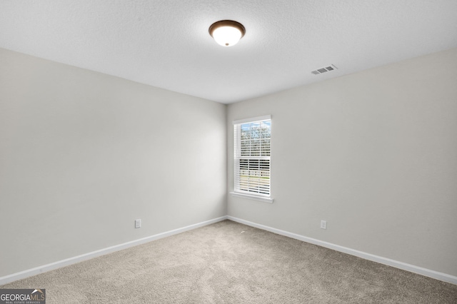 carpeted spare room with a textured ceiling