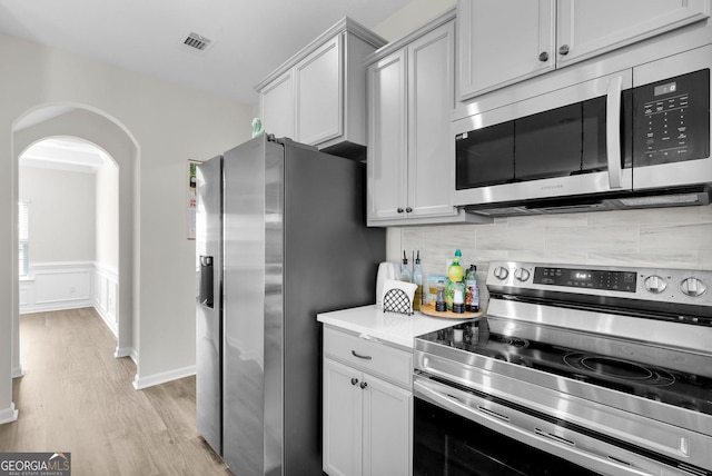 kitchen featuring light hardwood / wood-style floors, backsplash, and appliances with stainless steel finishes