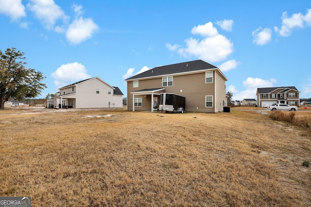 rear view of property featuring a lawn