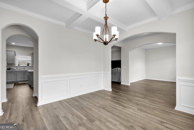 unfurnished dining area with beamed ceiling, light hardwood / wood-style floors, and ornamental molding