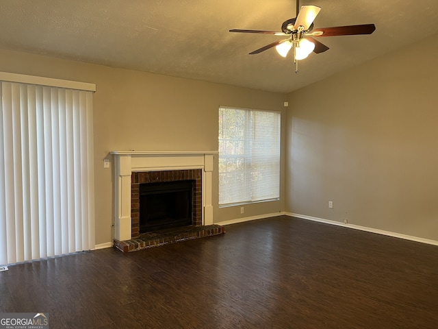 6268 Marbut Farms Trl, Lithonia, GA 30058 - unfurnished living room with wood finished floors, a ceiling fan, a brick fireplace, vaulted ceiling, and a textured ceiling