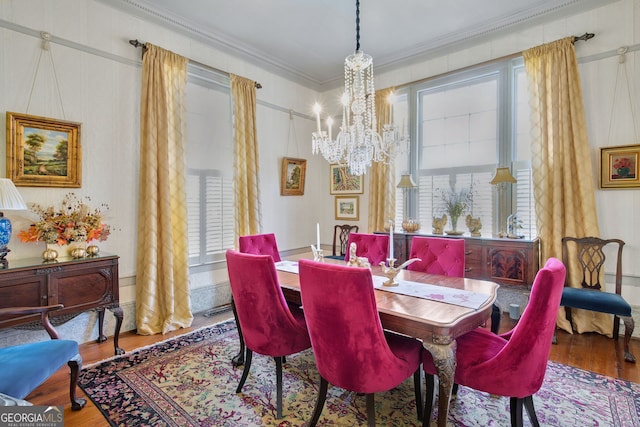 dining room featuring wood-type flooring, a notable chandelier, and ornamental molding