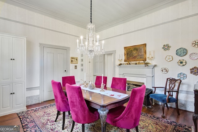 dining space featuring dark hardwood / wood-style flooring, ornamental molding, and a chandelier