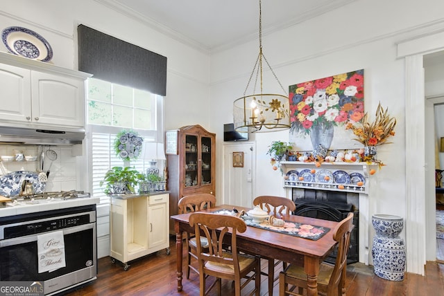 dining room featuring dark hardwood / wood-style flooring, crown molding, and a chandelier