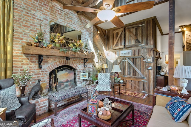 living room featuring ceiling fan, wood-type flooring, and beamed ceiling