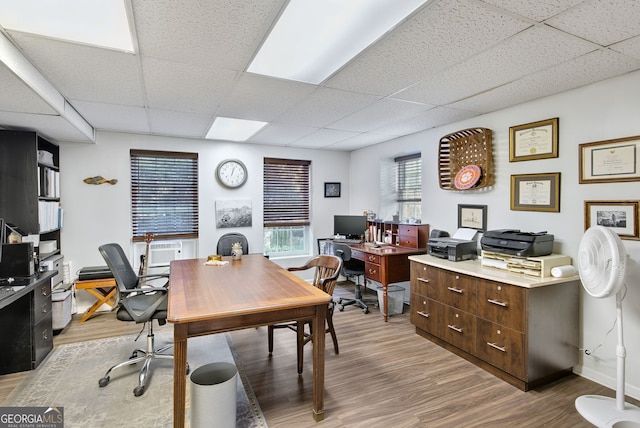 office area featuring light wood-type flooring and a drop ceiling