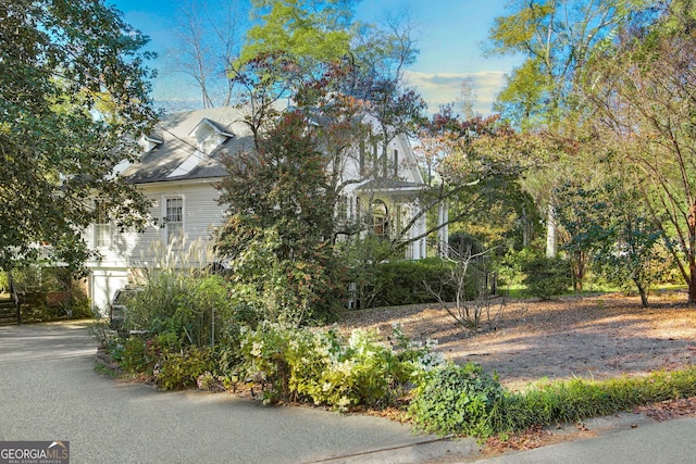 view of property hidden behind natural elements featuring a garage