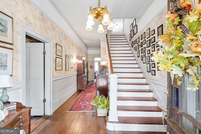 staircase featuring a chandelier and hardwood / wood-style flooring