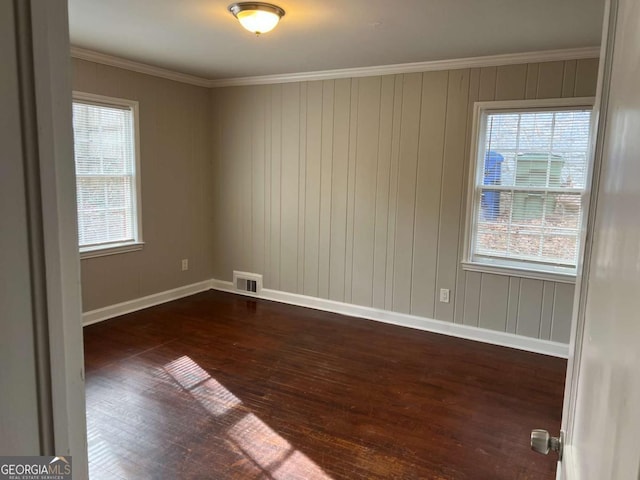 spare room with crown molding and dark wood-type flooring