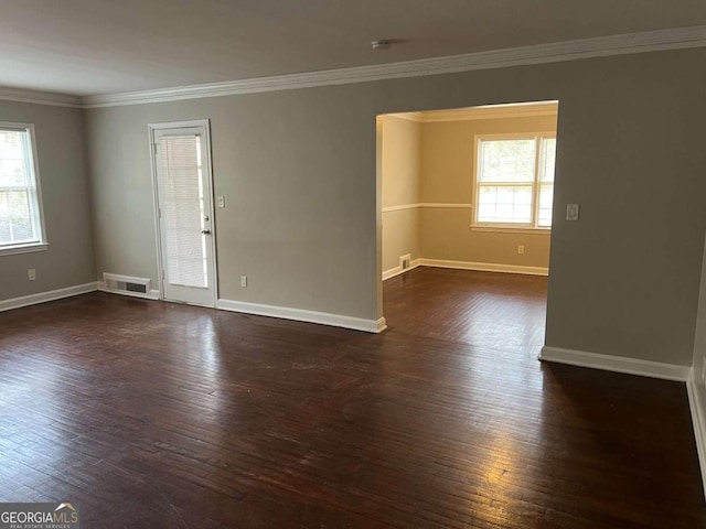 empty room with ornamental molding, dark hardwood / wood-style flooring, and a healthy amount of sunlight