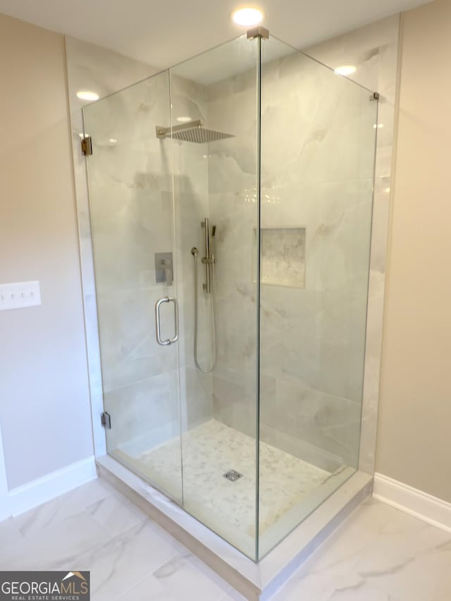 full bath with baseboards, marble finish floor, and a stall shower