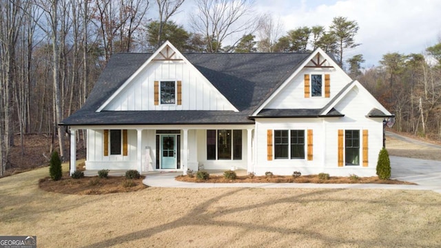 modern farmhouse style home featuring a porch and a front lawn