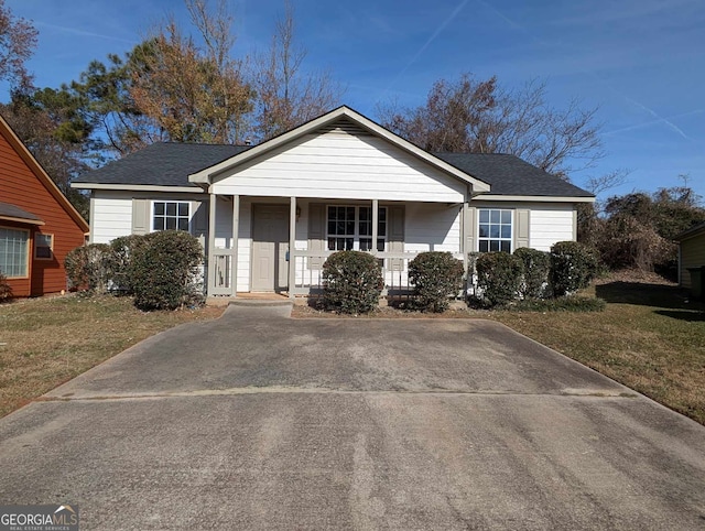 view of front of house featuring covered porch and a front yard