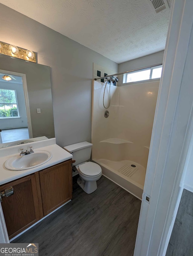 bathroom featuring a wealth of natural light, hardwood / wood-style floors, and walk in shower