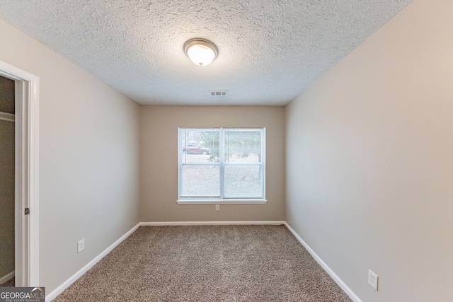 empty room featuring carpet and a textured ceiling