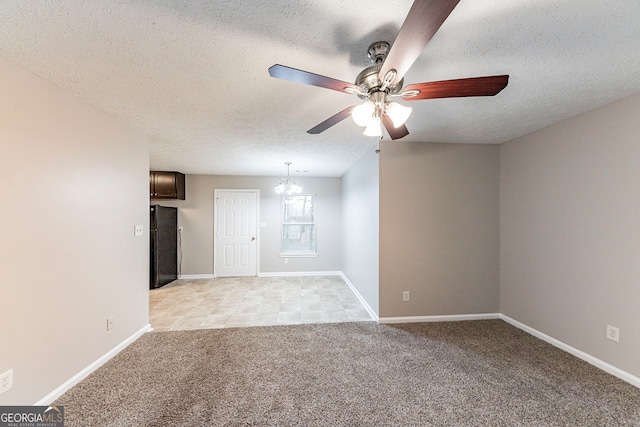 unfurnished living room featuring light carpet, a textured ceiling, and ceiling fan with notable chandelier