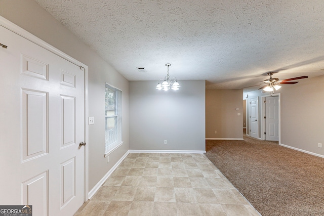 spare room with light carpet, a textured ceiling, and ceiling fan with notable chandelier