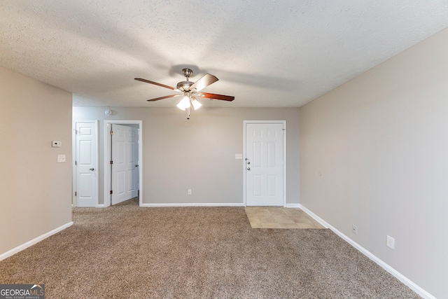 carpeted spare room with a textured ceiling and ceiling fan