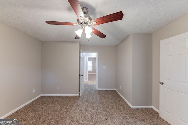 carpeted spare room with a textured ceiling and ceiling fan