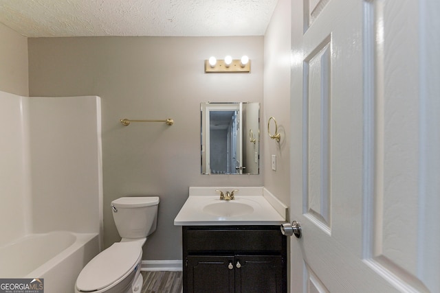 full bathroom with vanity, toilet, wood-type flooring, and a textured ceiling