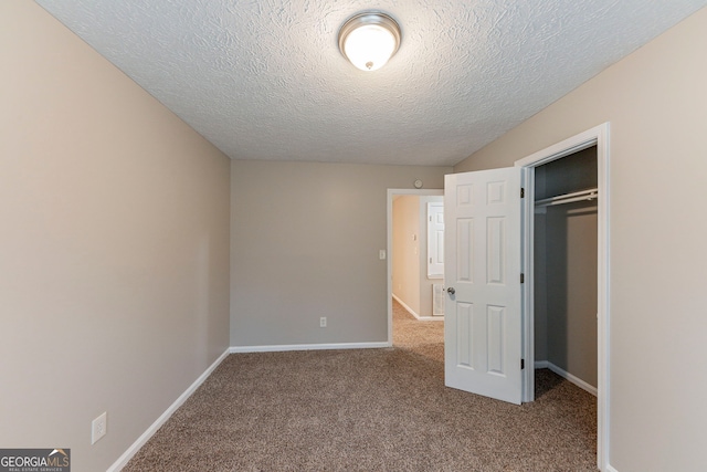 unfurnished bedroom with carpet, a textured ceiling, and a closet