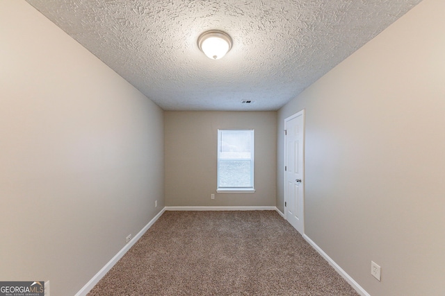 carpeted empty room with a textured ceiling