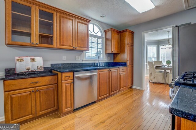 1103 Etowah Valley Ln, Woodstock, GA 30189 - kitchen with sink, light wood-type flooring, a textured ceiling, stainless steel appliances, and a chandelier