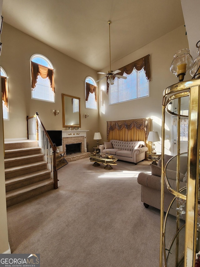 living room with ceiling fan, carpet floors, and a fireplace