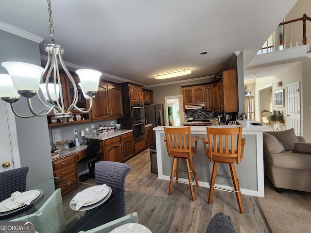 kitchen featuring kitchen peninsula, a kitchen breakfast bar, light hardwood / wood-style flooring, and plenty of natural light