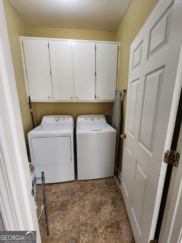 laundry area with washer and clothes dryer and cabinets