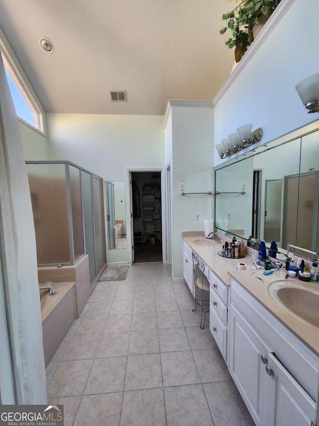 bathroom featuring shower with separate bathtub, vanity, and tile patterned floors