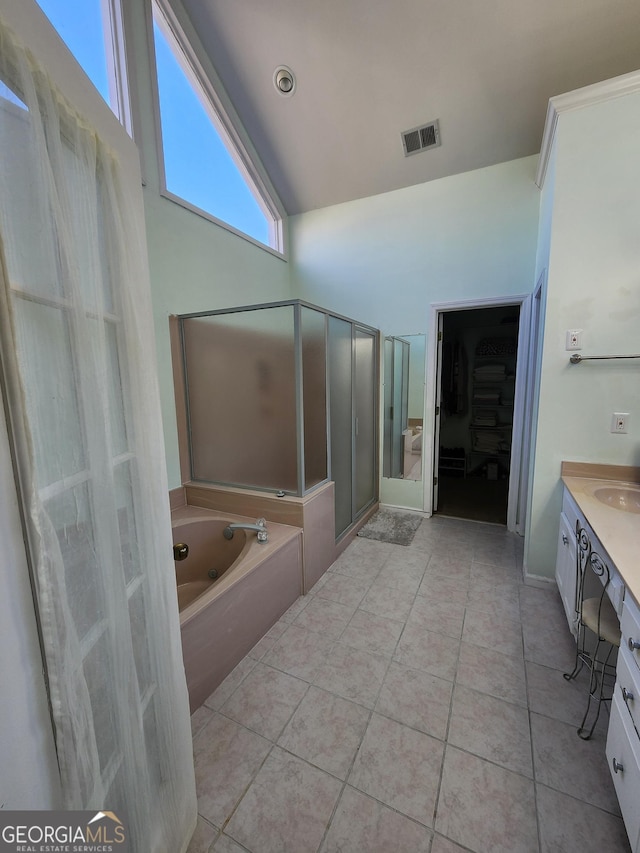 bathroom featuring tile patterned flooring, shower with separate bathtub, vanity, and vaulted ceiling