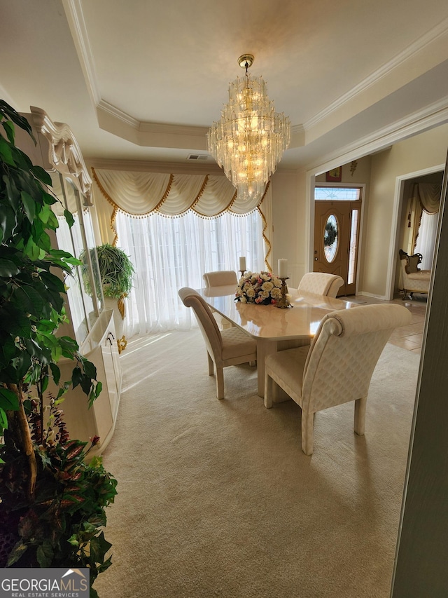 carpeted dining space featuring crown molding and a chandelier