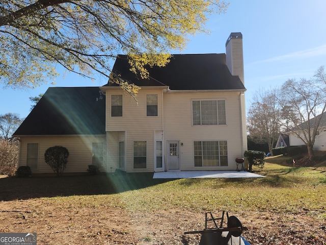 rear view of house featuring a lawn and a patio area