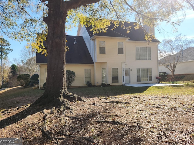 back of property with a patio and a lawn