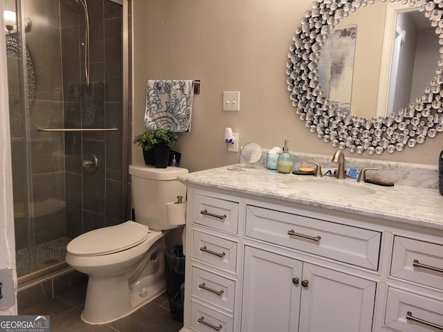 bathroom with tile patterned floors, vanity, an enclosed shower, and toilet