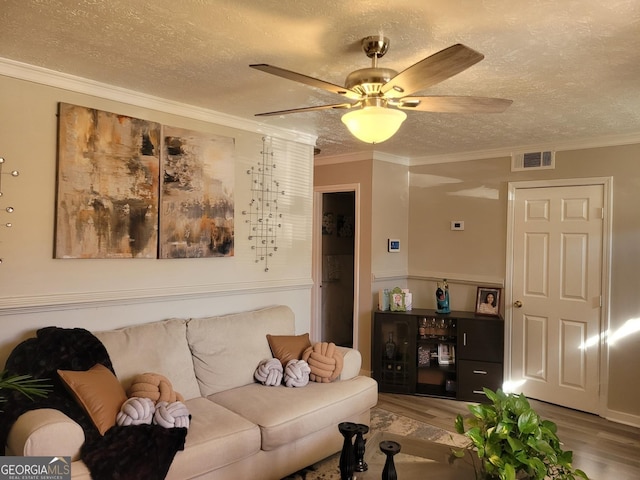 living room featuring crown molding, hardwood / wood-style floors, ceiling fan, and a textured ceiling