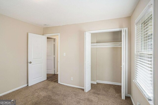 unfurnished bedroom featuring carpet flooring and a closet