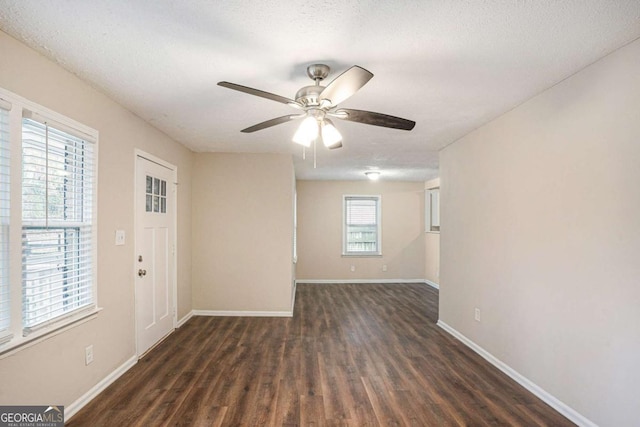 interior space with dark hardwood / wood-style floors, ceiling fan, and a textured ceiling